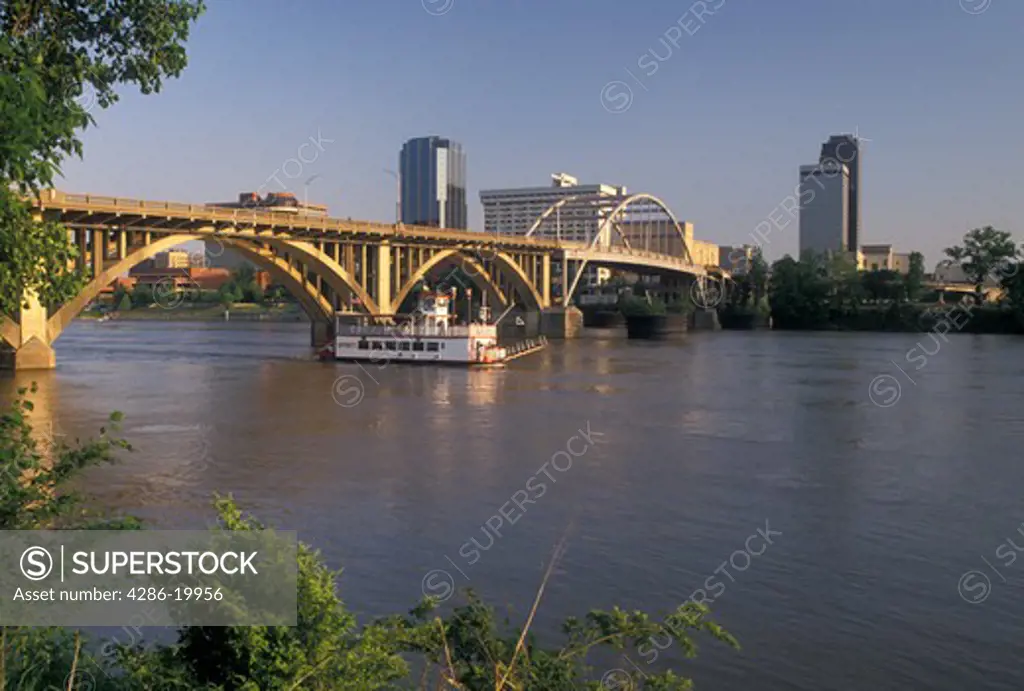 Little Rock, skyline, AR, Arkansas, A riverboat cruises under a bridge crossing the Arkansas River and a view of the downtown skyline of Little Rock.