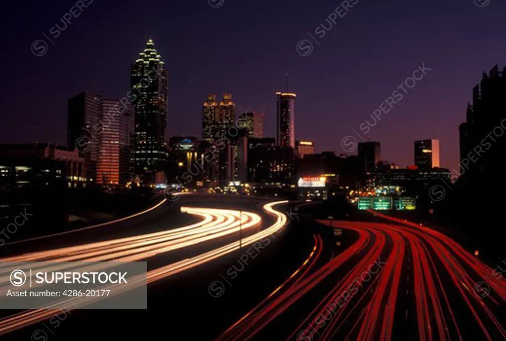 Atlanta, GA, Georgia, Traffic lights streak on I-75/I-85 at sunset and view of the skyline of downtown Atlanta.