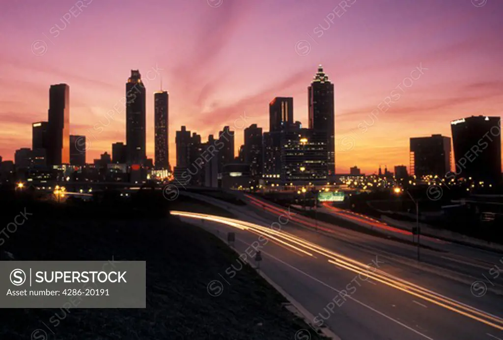 Atlanta, GA, Georgia, Traffic lights streak on Freedom Parkway at sunset and view of the skyline of downtown Atlanta.