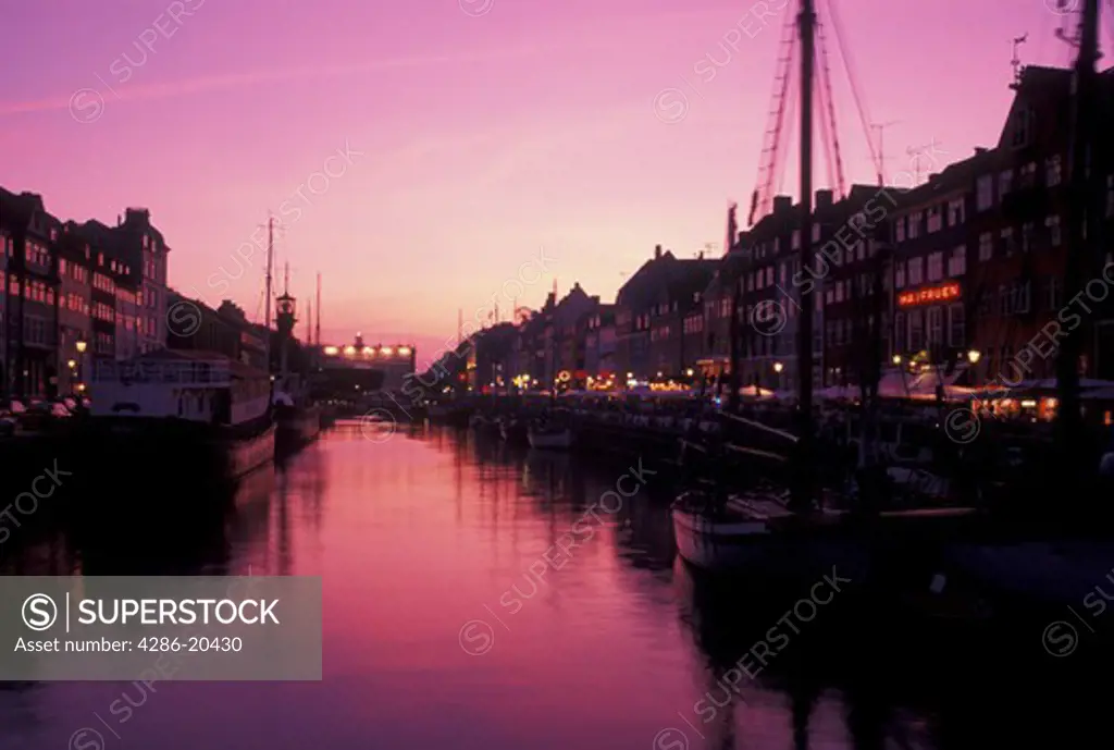 Denmark, Copenhagen, canal, Scandinavia, Sjaelland, Europe, Boats docked along Nyhavn (New Harbor) in the evening in the scenic city of Copenhagen
