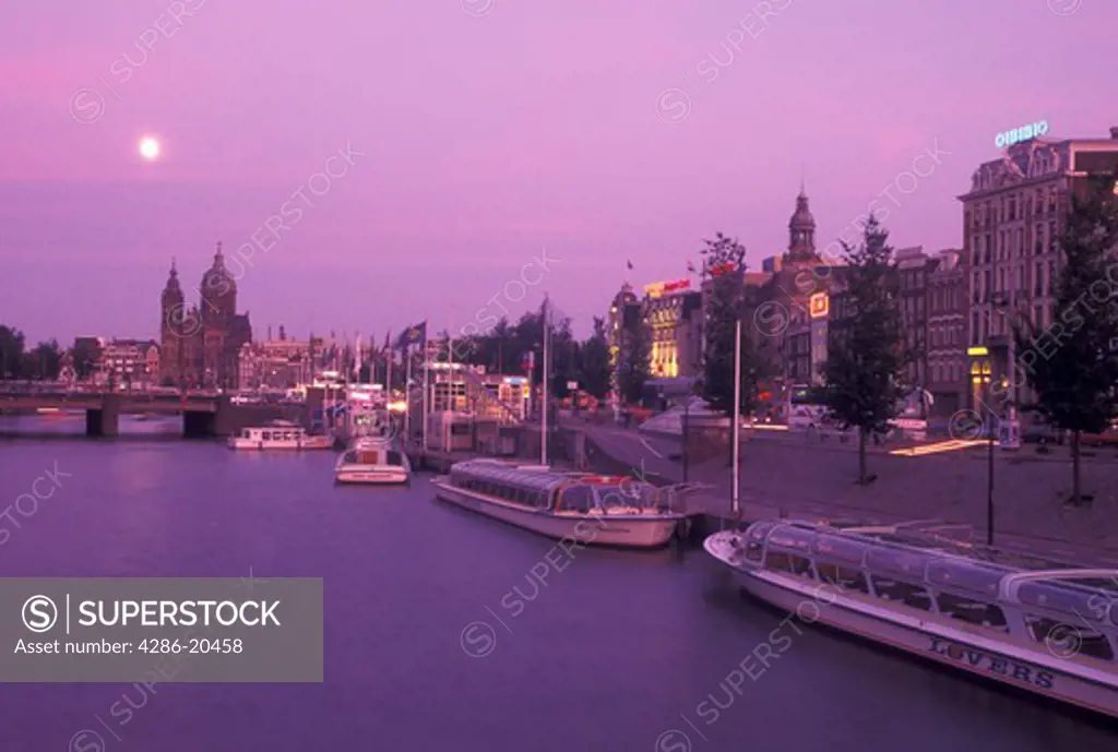 Netherlands, Amsterdam, Holland, Noord-Holland, Europe, Full moon rising over canal in the evening in Amsterdam.