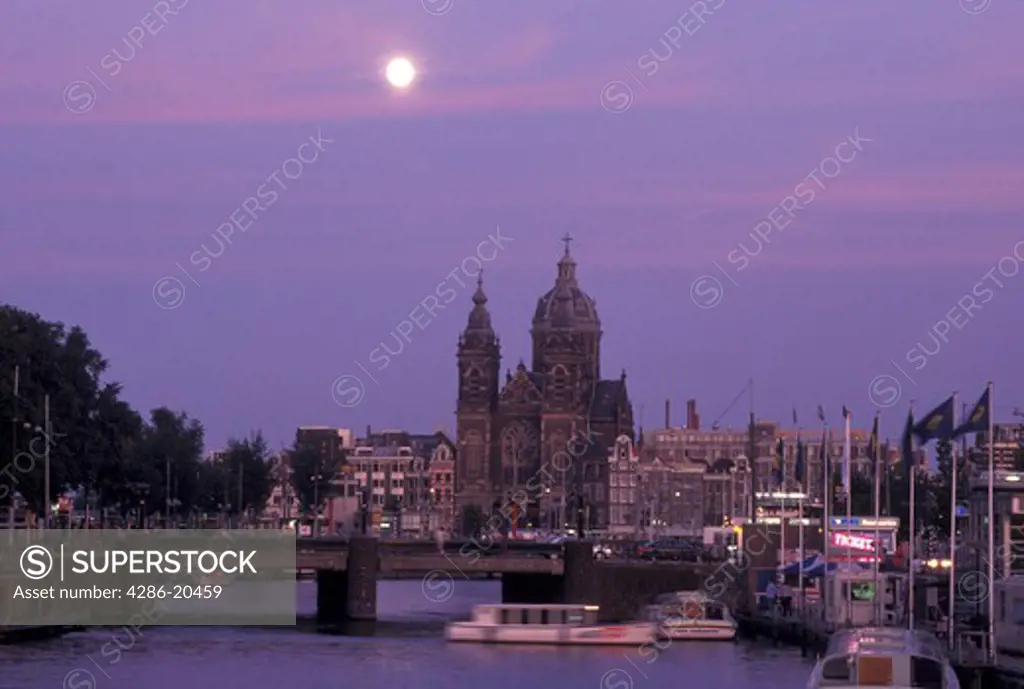 Amsterdam, Holland, Netherlands, Noord-Holland, Europe, Full moon rising over canal in the evening in Amsterdam.