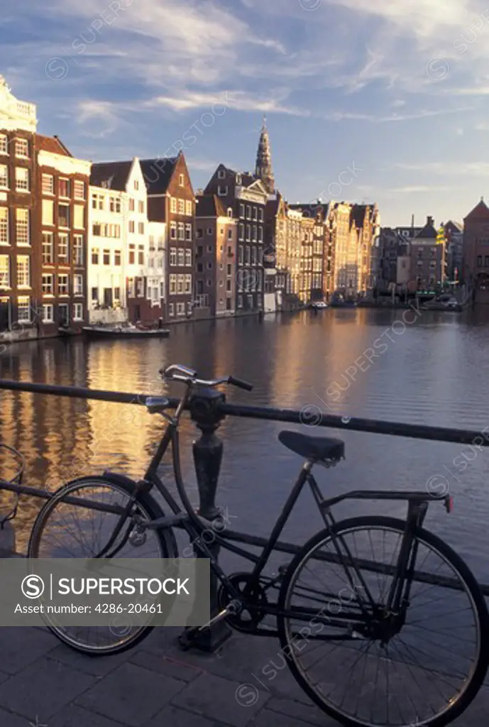 Amsterdam, Holland, Netherlands, Noord-Holland, Europe, Bikes lean against railing along a canal in Amsterdam.