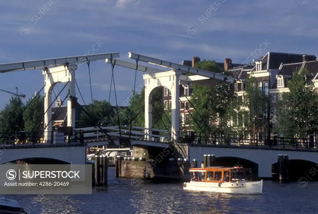 drawbridge, Amsterdam, Holland, Netherlands, Noord-Holland, Europe, Boat cruises under Skinny Drawbridge on a canal in Amsterdam.