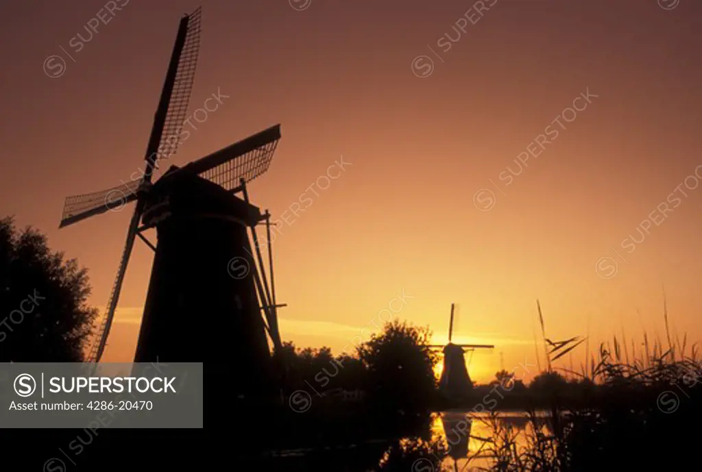 windmill, sunrise, Kinderdijk, Netherlands, Holland, Zuid-Holland, Europe, Mills of Kinderdijk, Working windmills along a canal in Kinderdijk at sunrise.