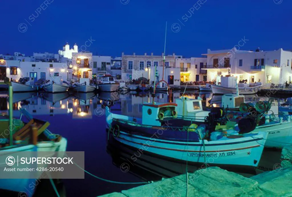 Paros, Greek Islands, Naoussa, Cyclades, Greece, Europe, Fishing boats docked in Naoussa Harbor in the evening on Paros Island on the Aegean Sea.