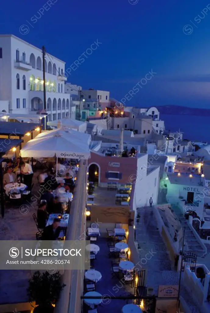 outdoor caf, Santorini, Greek Islands, Fira, Cyclades, Greece, Europe, Outdoor restaurants and terraces in the village of Fira in the evening on the steep hillside of Santorini Island overlooking the Aegean Sea.