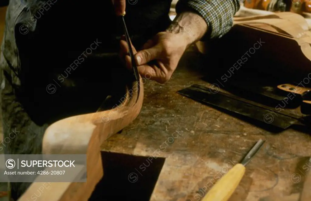 Woodworkers hands crafting chair leg