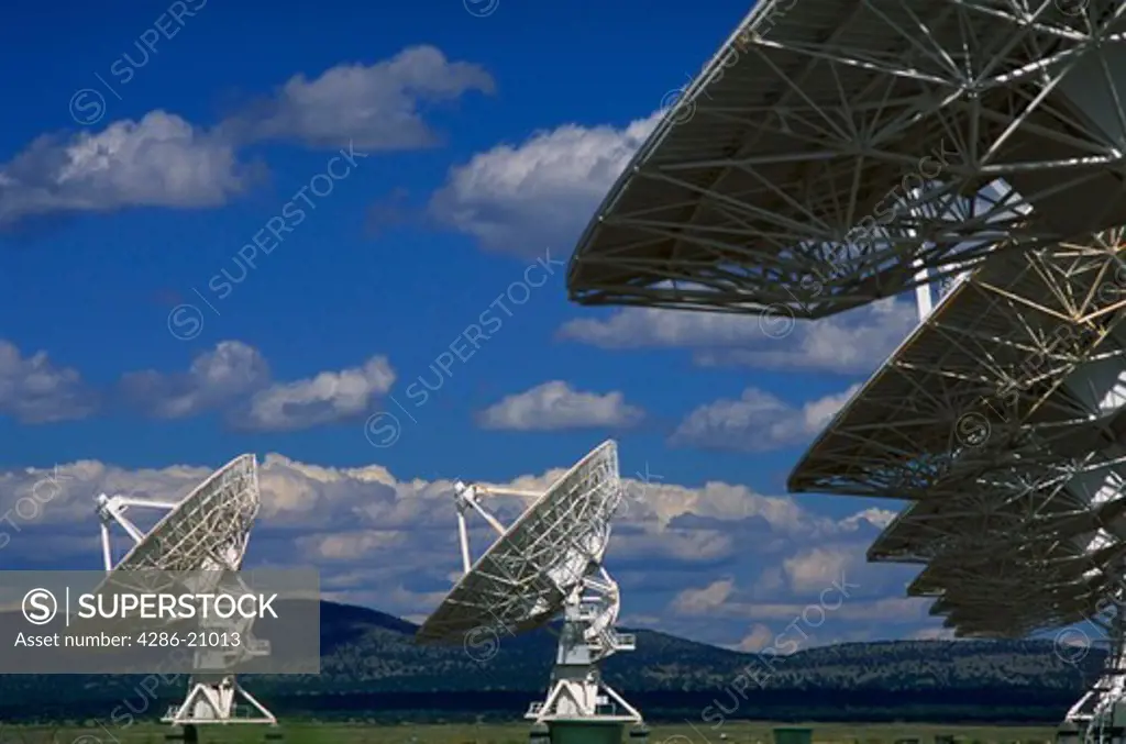 Very large array satellite dishes in New Mexico with blue sky and clouds in background.