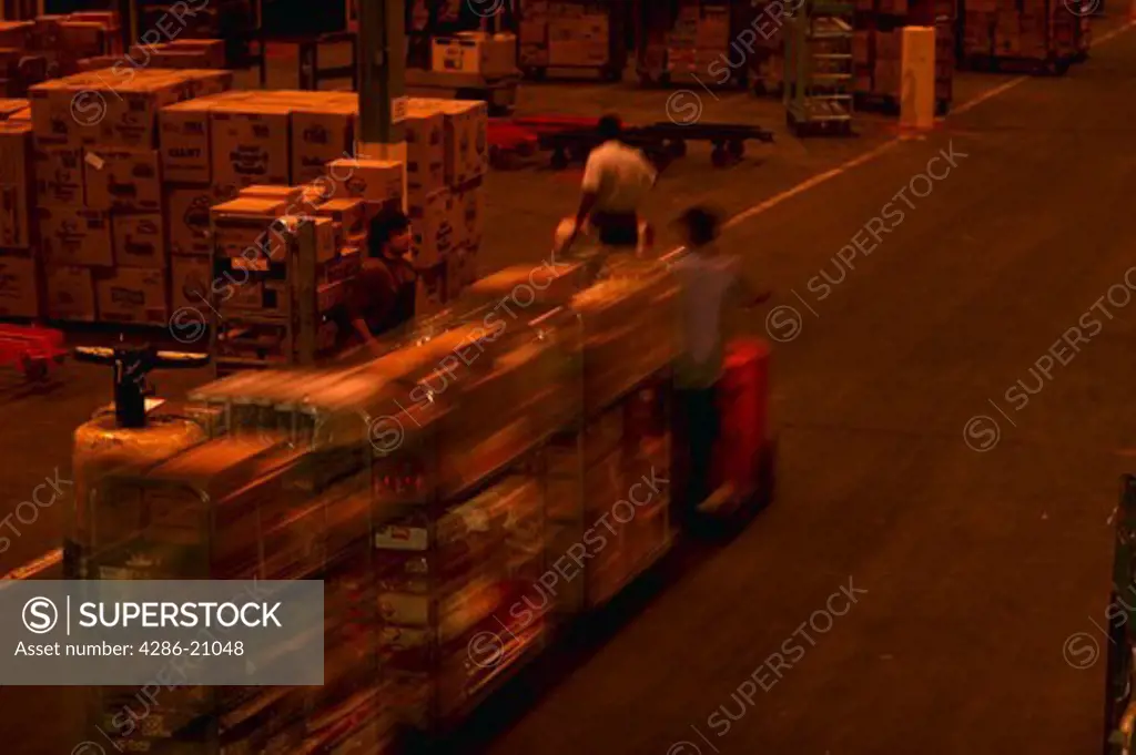 Worker driving a tram in a grocery store shipping facility in Jessup, Maryland.