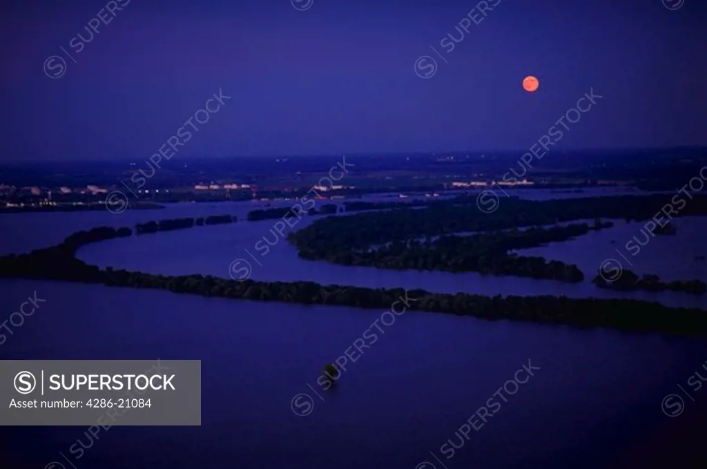 Aerial view of flooding on the Mississippi River in early evening under a full moon.