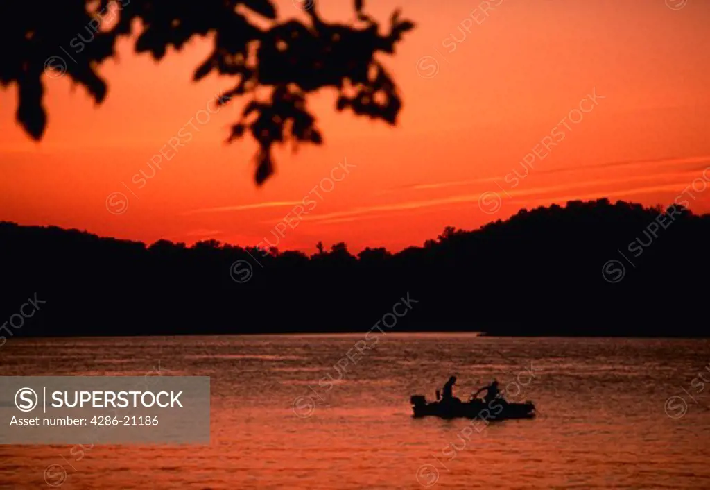 Fishermen on lake at sunset