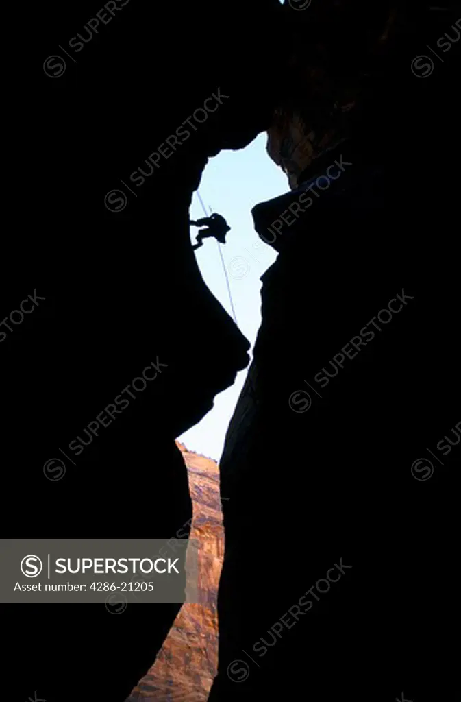 Rappeller silhouetted between cliffs, Zion National Park, southern Utah.
