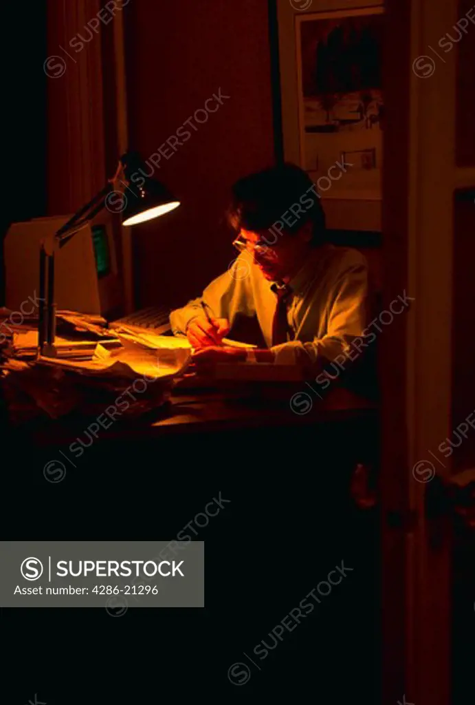 Male executive doing late night office work.MR
