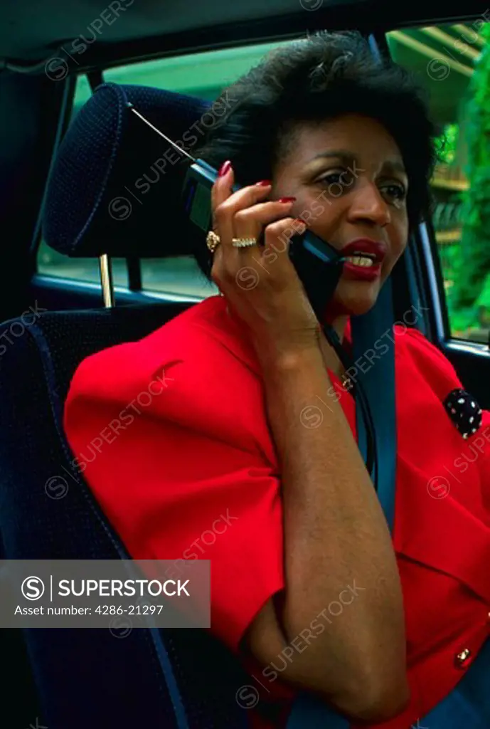 Female executive using cellular car phone.MR