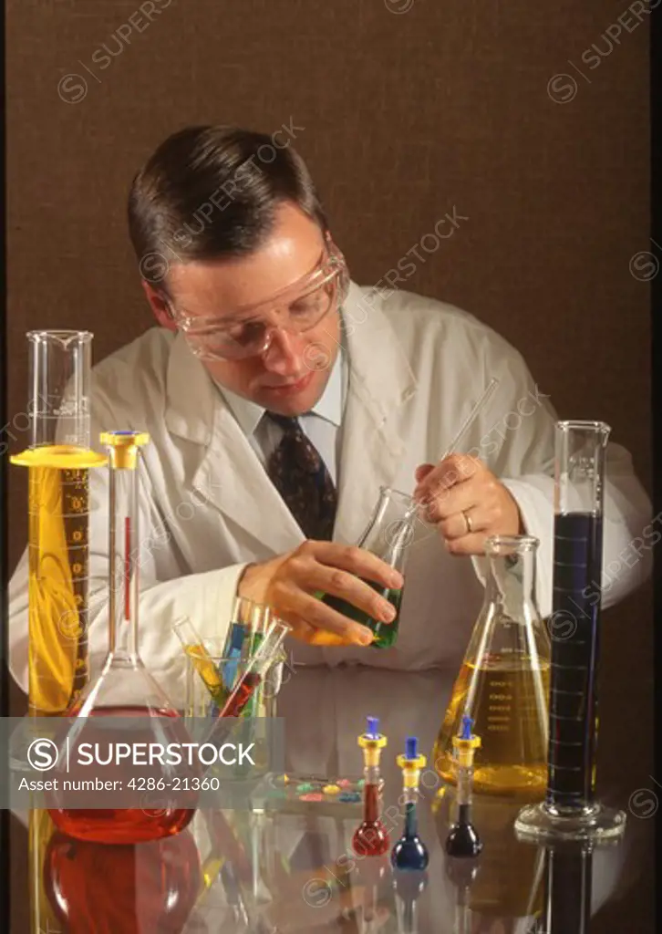 Chemist stirs fluid in flask 