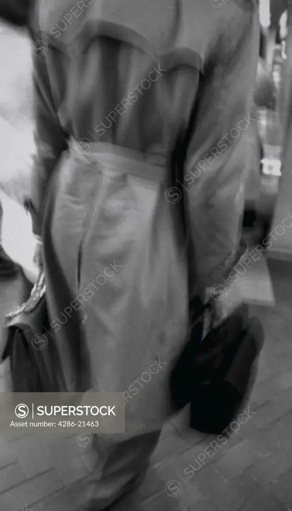 Businessman wearing trenchcoat and carrying breifcase, with blurred effect.