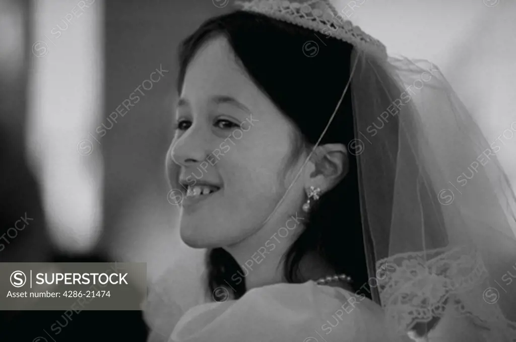 Young girl smilng during her first communion.