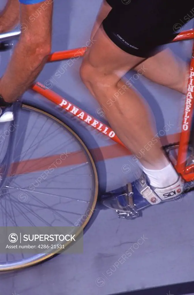 A close up of a man cycling on an oval track in Portland, OR.