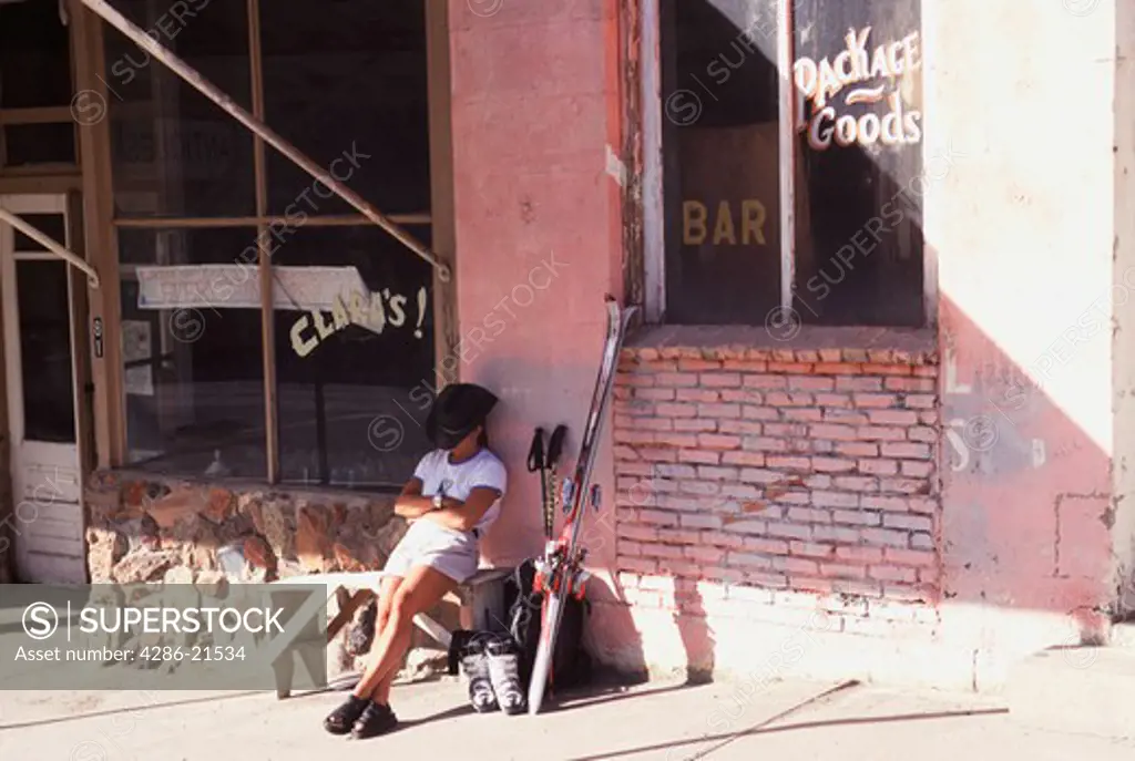 A woman resting in front of a liquor store in Austin Nevada.
