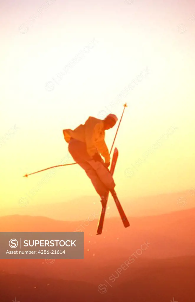 A man jumping while skiing at sunset at Mount Hood, OR.