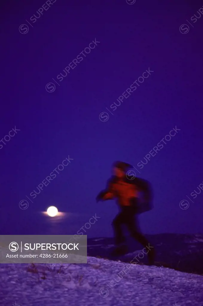 A man running on an alpine ridge in winter near Mount Judah, CA.