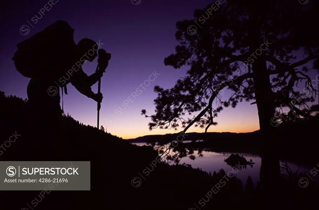 A man taking predawn photographs while hiking near Emerald Bay, CA.
