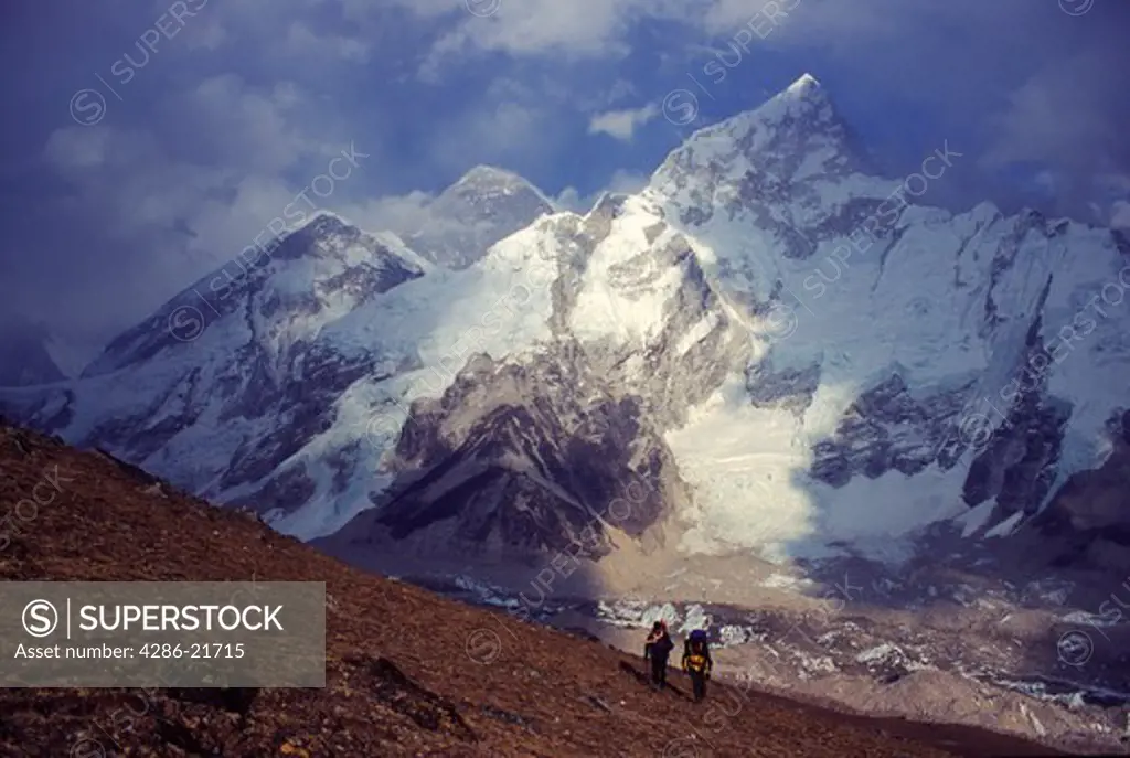 A couple hiking to the top of Kala Patar with Mount Everest in the background.
