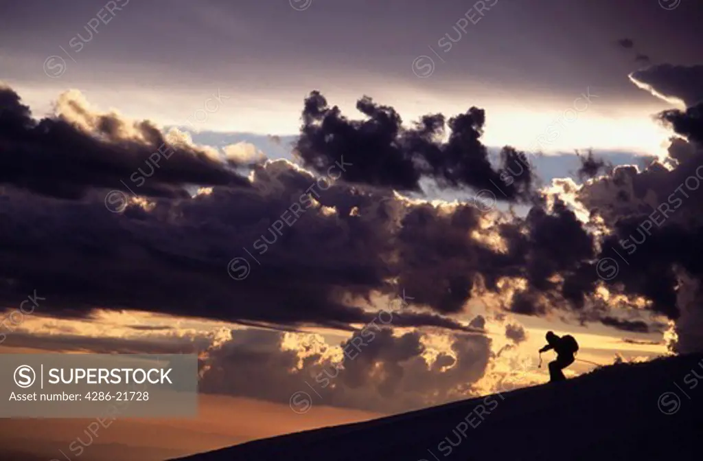 A man skiing at sunset during a clearing storm on Mount Hood, OR.