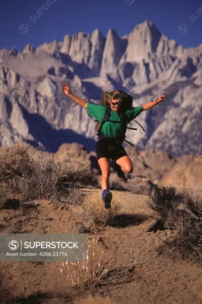 A woman leaping while hiking near Mount Whitney, CA.