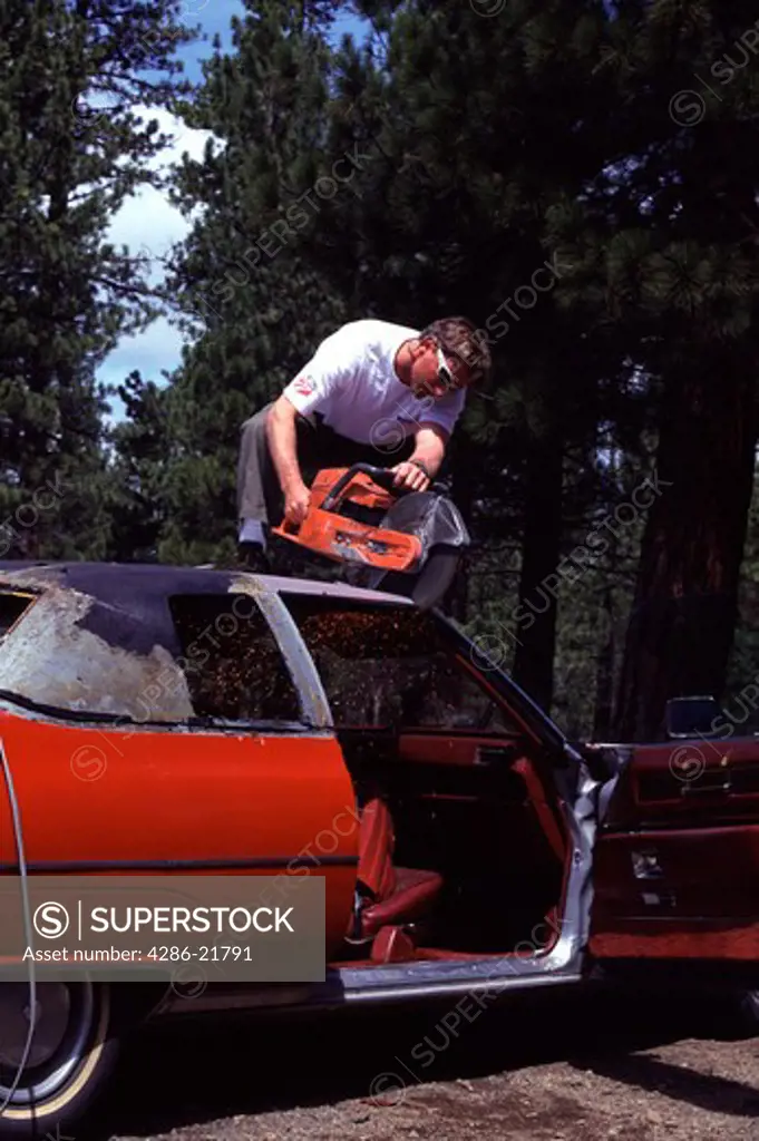 A man cutting the roof off a Cadillac car in Truckee, CA.