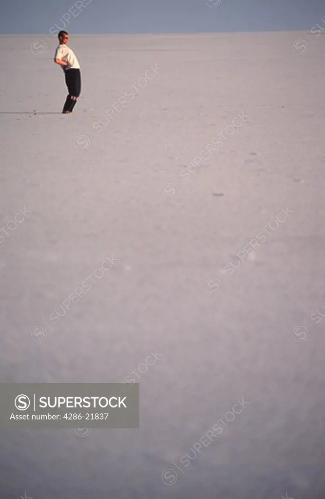 A man standing on the Bonneville Salt Flats in Utah.