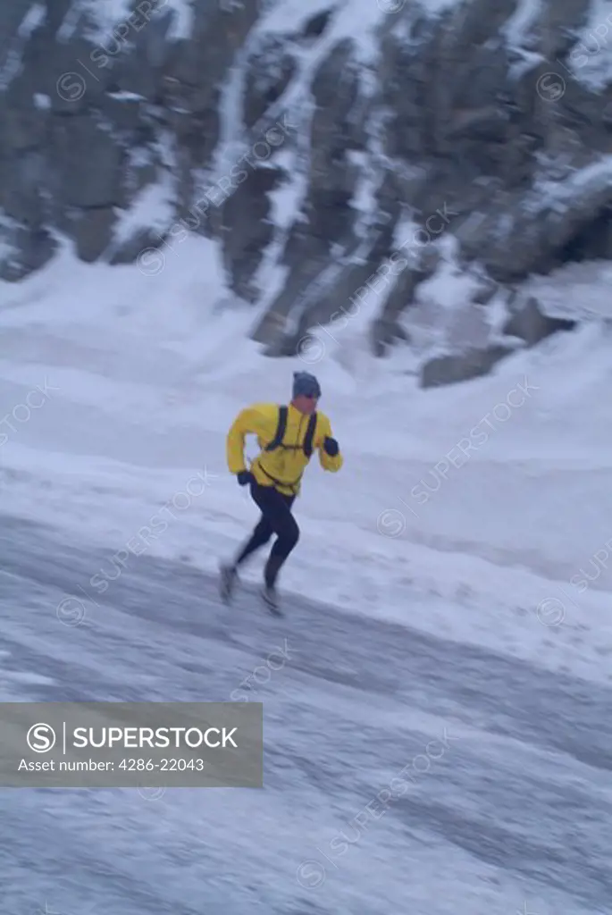 A man running on a snowy road during winter on Donner Summit, CA.