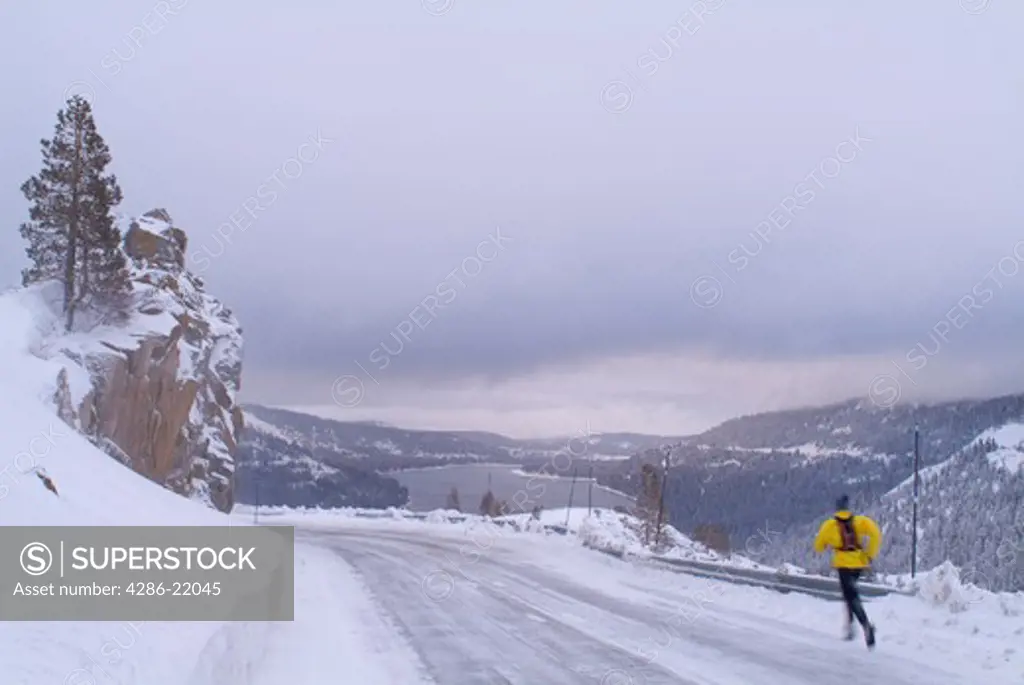A man running in the snow during winter on Donner Summit, CA.