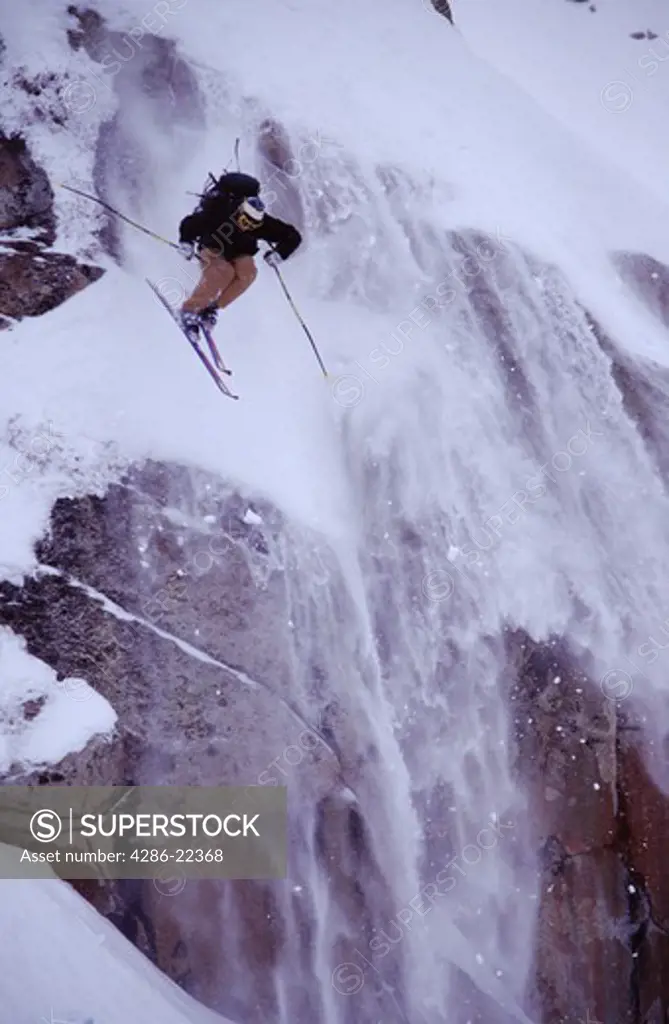 A man jumping on skis in the Utah Back country.