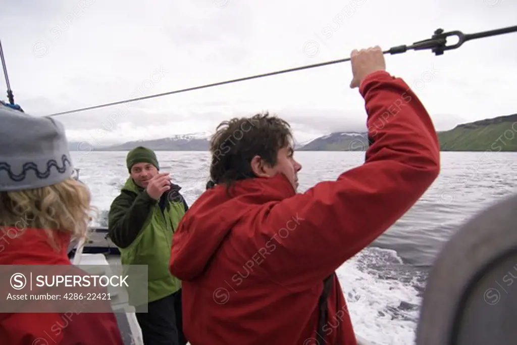 Friends on a fishing boat on a cloudy day in the Aleutian Islands.