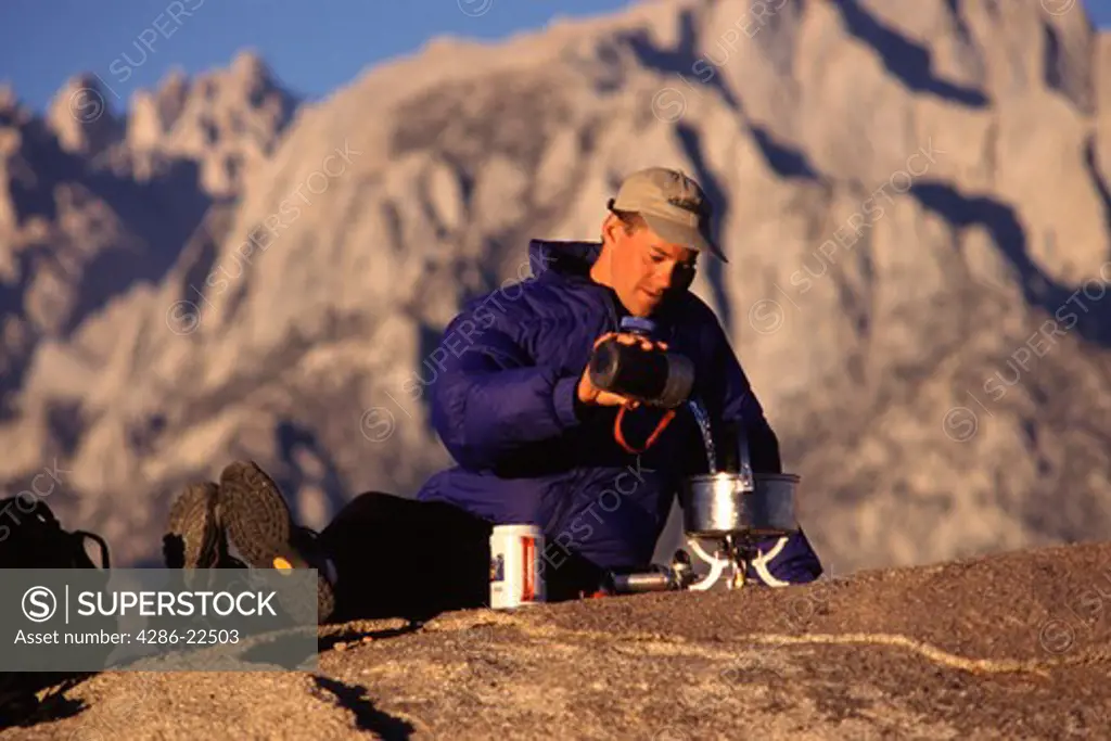A man cooking while camping near Mount Whitney in the Sierra mountains in California