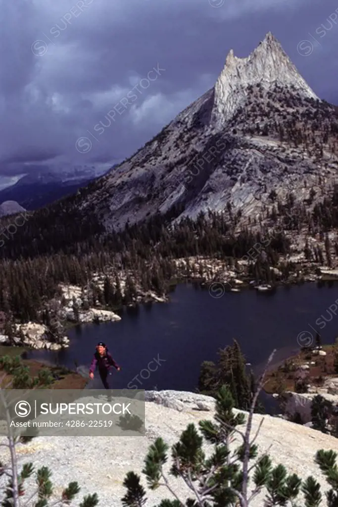 A woman hiking in the mountains of Yosemite National Park near Catherdral Peak in California.