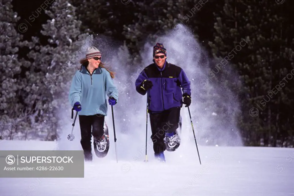 A couple running on snowshoes in powder snow in Squaw Valley, California.