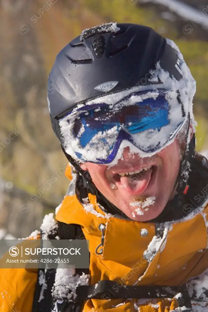 A happy skier with snow on his face.