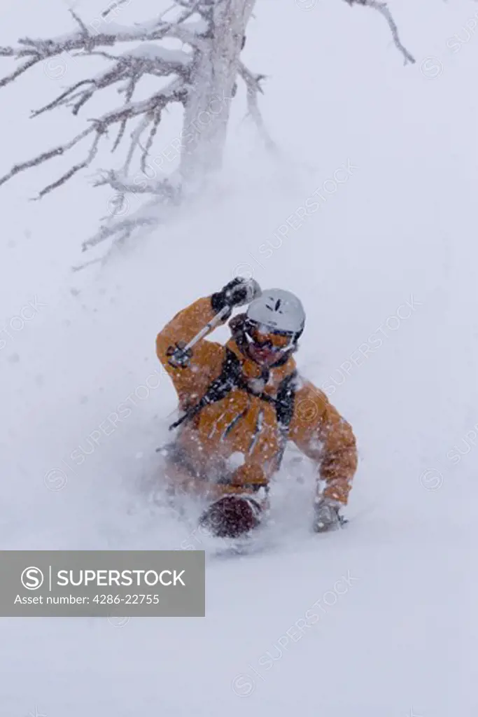 A man skiing deep powder snow in a storm Alpine Meadows in Lake Tahoe, California