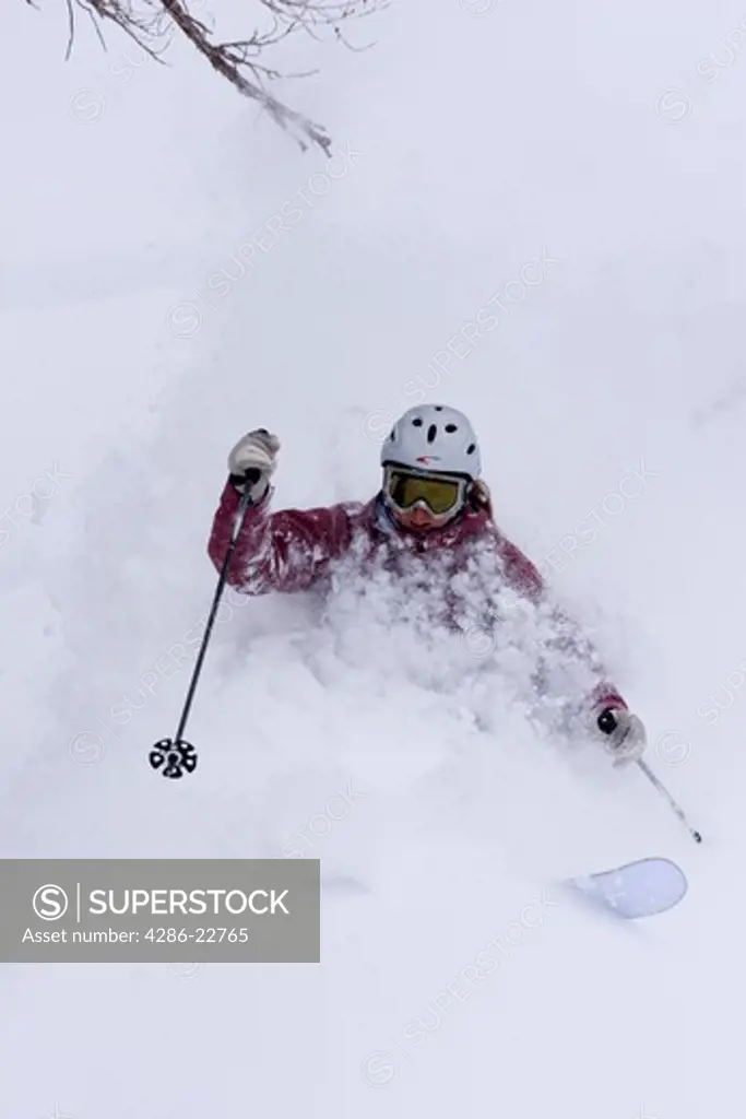 A woman skiing deep powder snow in a storm Alpine Meadows in Lake Tahoe, California