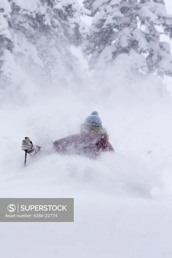 A woman skiing deep powder snow in a storm Alpine Meadows in Lake Tahoe, California