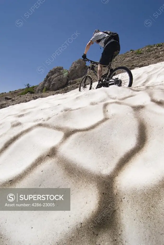 A man riding a mountain bike across snow on Donner summit in California