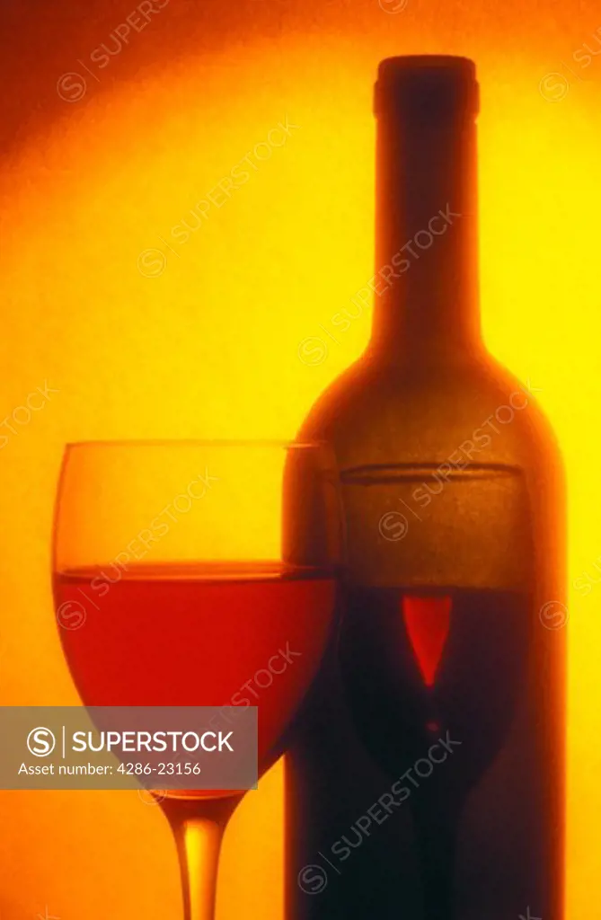 glass of wine and wine bottle warm tones