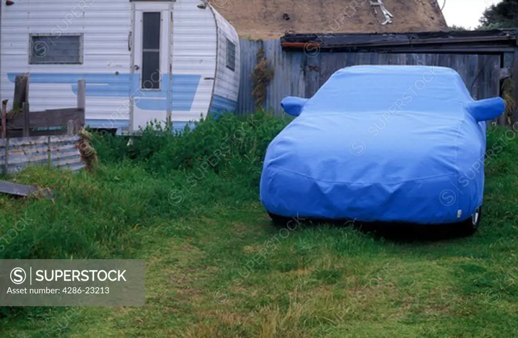 USA, California. Mendocino. Car blue car cover on car in yard