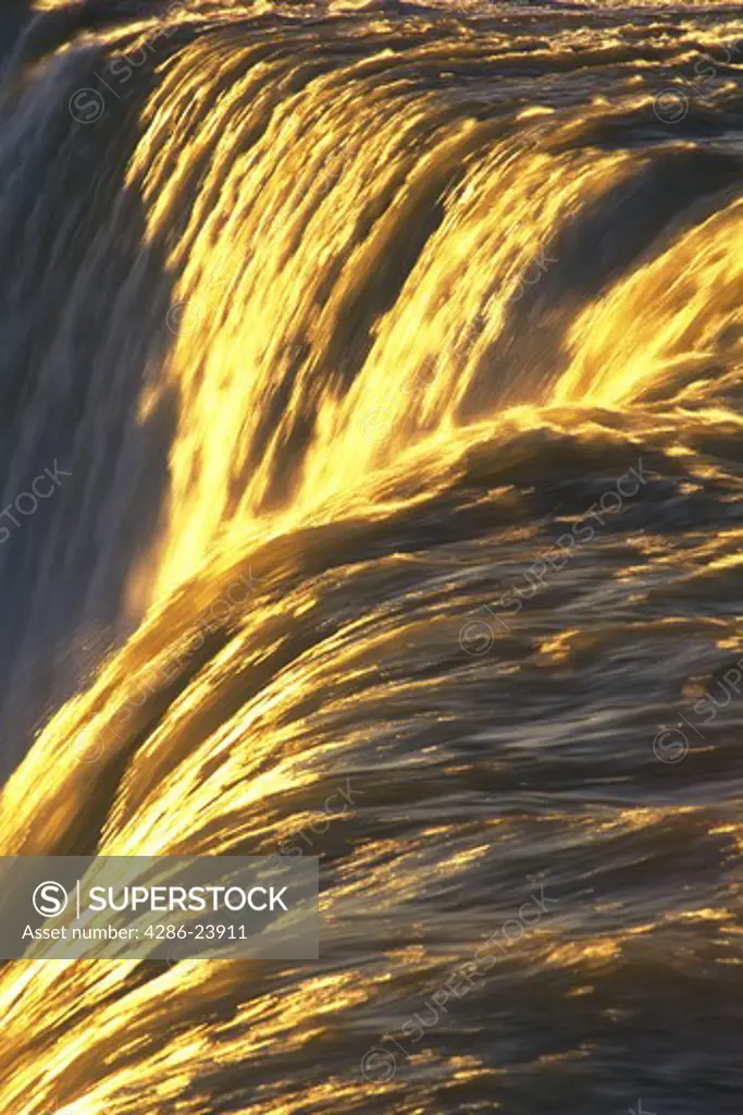 Canada, Ontario, Niagara Falls, close-up of waterfalls with golden sunlight  highlighting the water