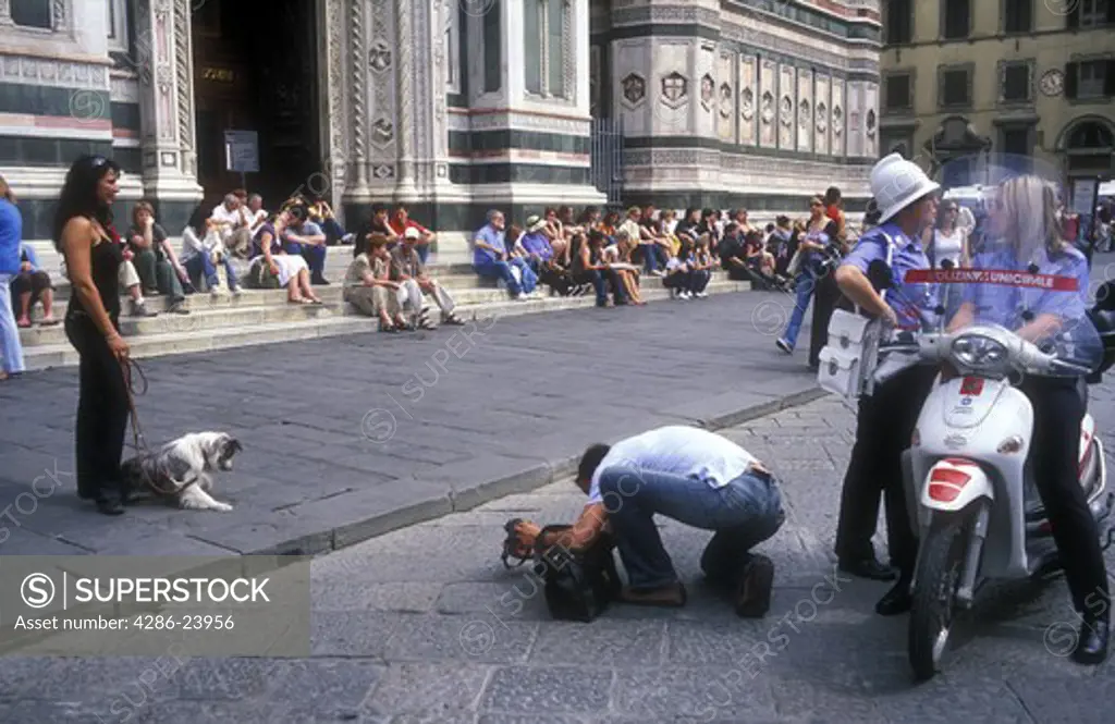 Italy, Florence, Cathedral of Santa Maria del Fiore (The Duomo) Piazza del Duomo, tourist taking photos of girlfriend with dog