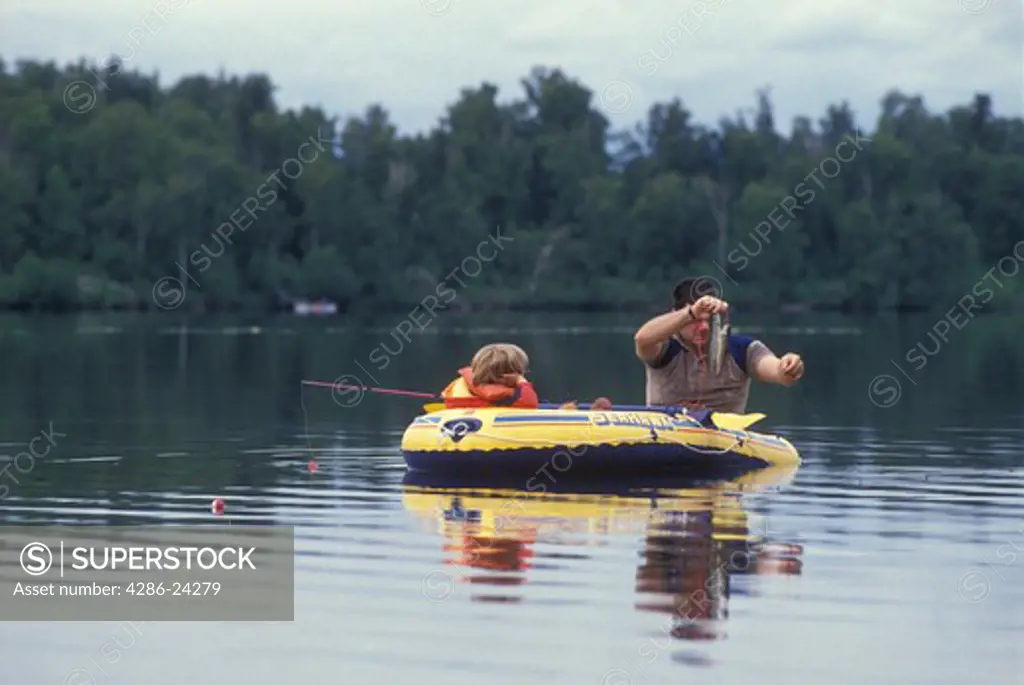 USA, Alaska, Chugiak, Beach Lake, father and son fishing in inflatable raft