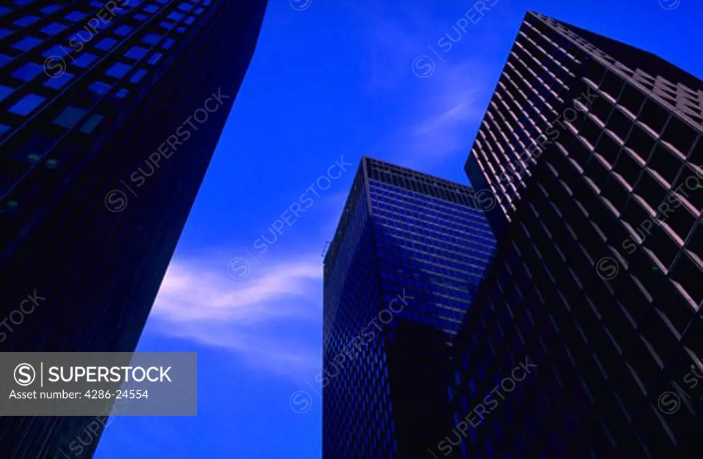 View of skyscrapers looking up from the street with blue sky above.